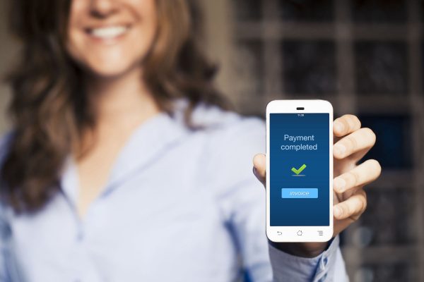 Payment completed message. Girl showing her mobile phone.